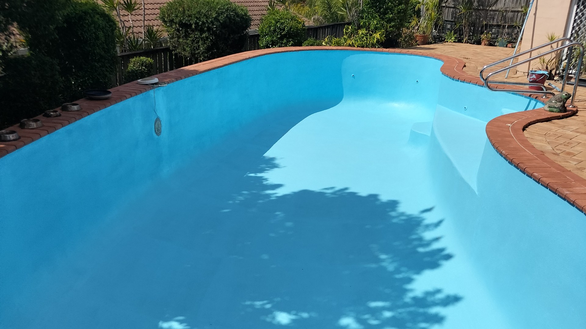 Freshly resurfaced backyard pool at sunset